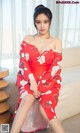 a woman in a red dress sitting on a couch