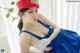 A woman in a blue dress and a red hat.