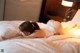 A woman laying on a bed in a white lingerie.