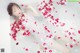 A woman laying in a bathtub filled with rose petals.